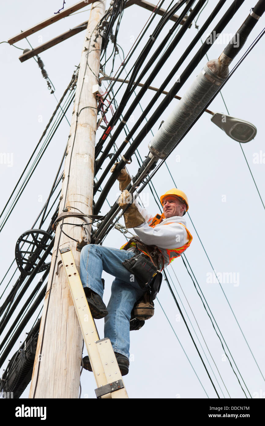 Cable lineman standing on ladder hires stock photography and images