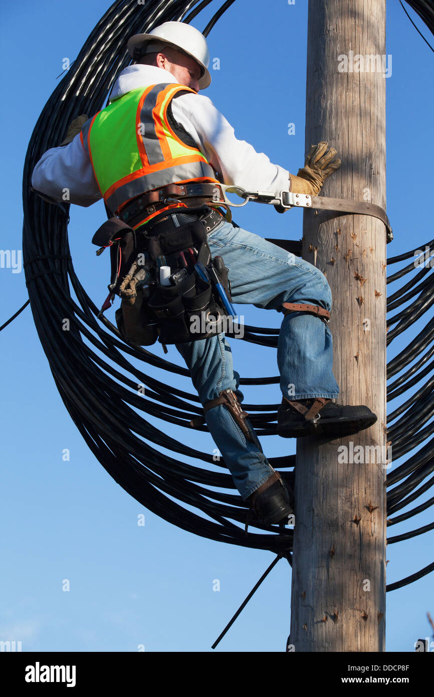 Cable lineman raising new cable up onto power pole Stock Photo Alamy