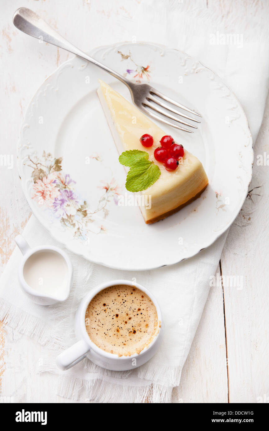 Cheesecake with red currant with coffee on plate Stock Photo