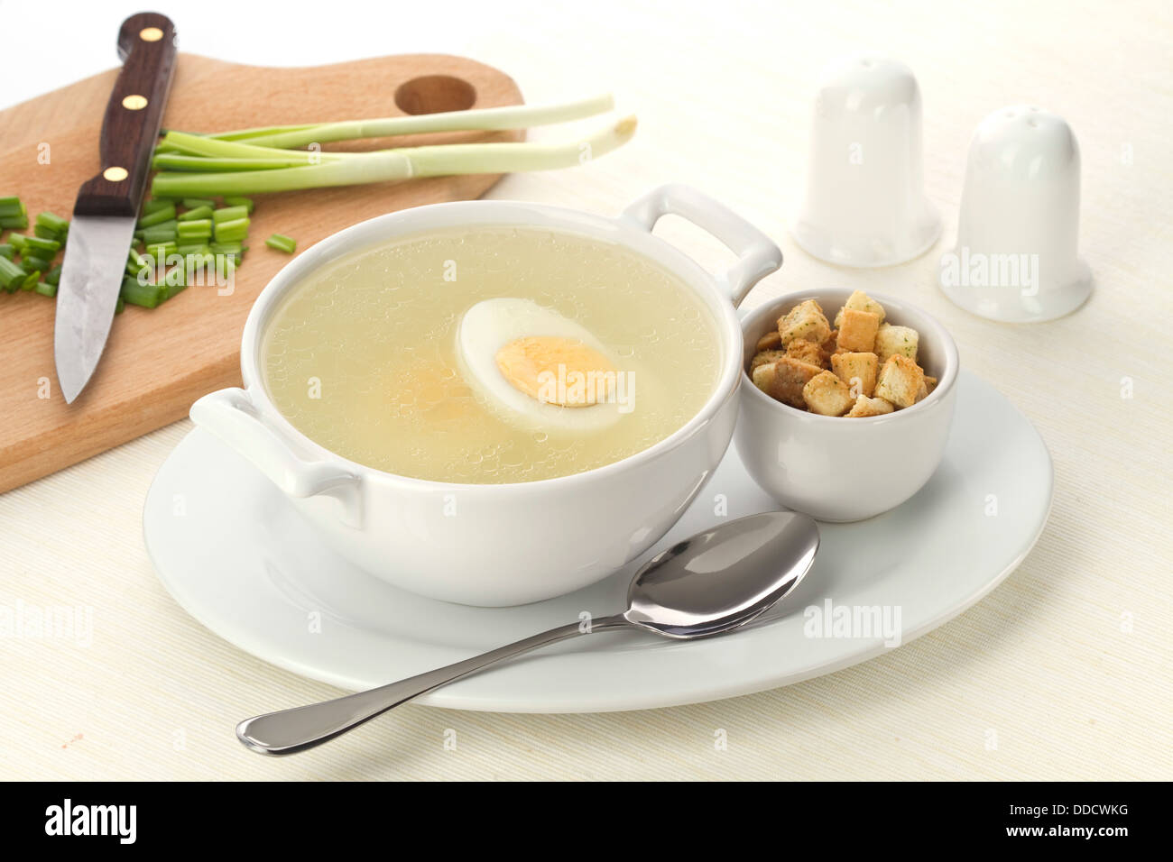 Served place setting with chicken broth and croutons Stock Photo