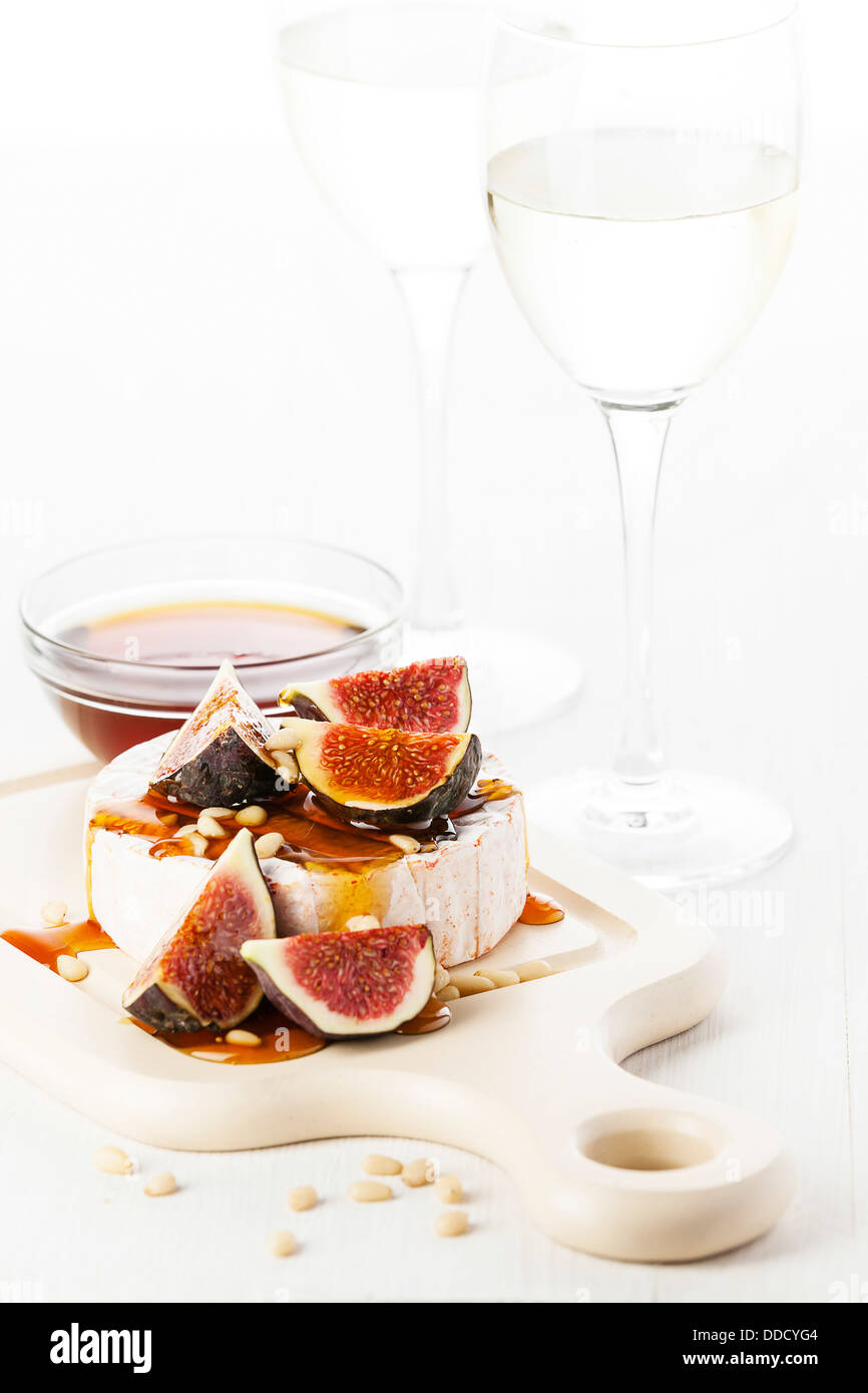 Camembert cheese, figs and honey on light background Stock Photo