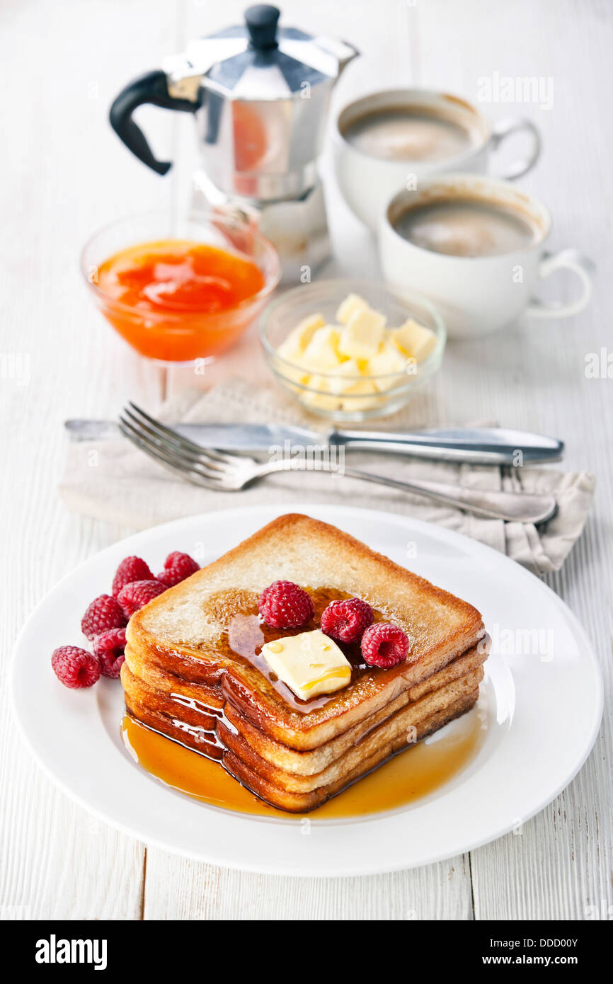 French toast with raspberries, maple syrup and butter Stock Photo