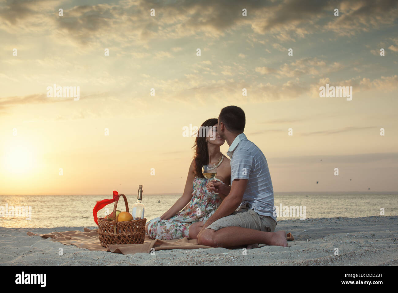 Couple On Beach With Luxury Wine Picnic during beautiful sunset. Dawn ...
