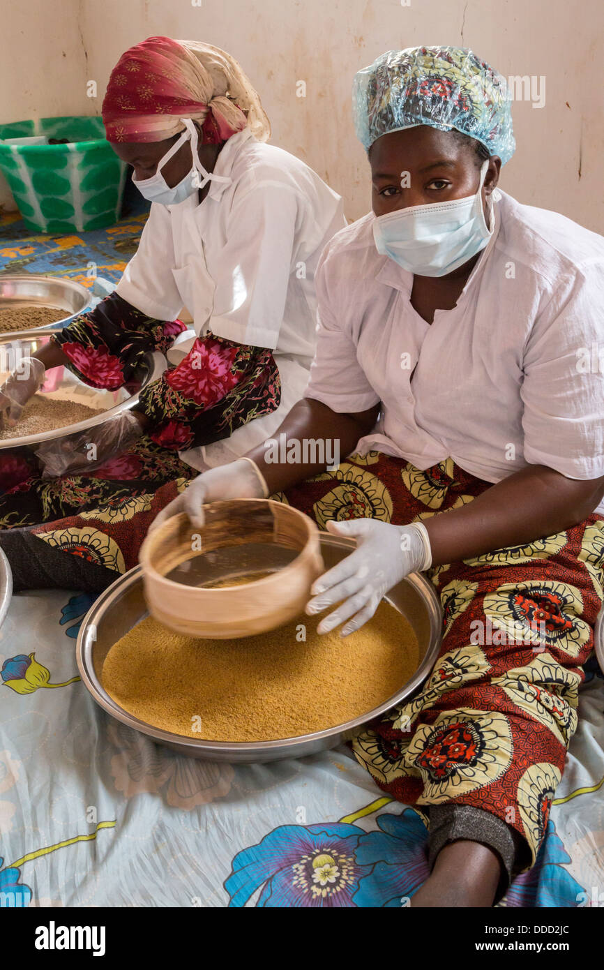 Staff Members of Millet Processing Facility Sifting Grain to Remove Debris, Kajmoor Village, Senegal. An Africare Project. Stock Photo