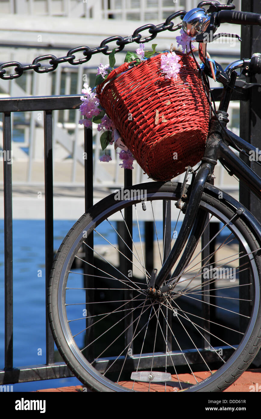 Old fashioned bicycle with colorful basket and flowers,leaning against
