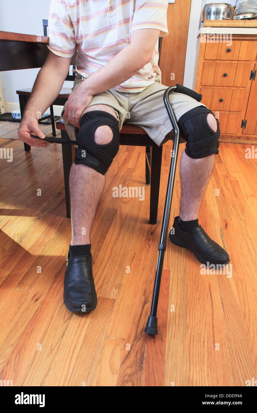 Man adjusting braces on his knees after anterior cruciate ligament (ACL