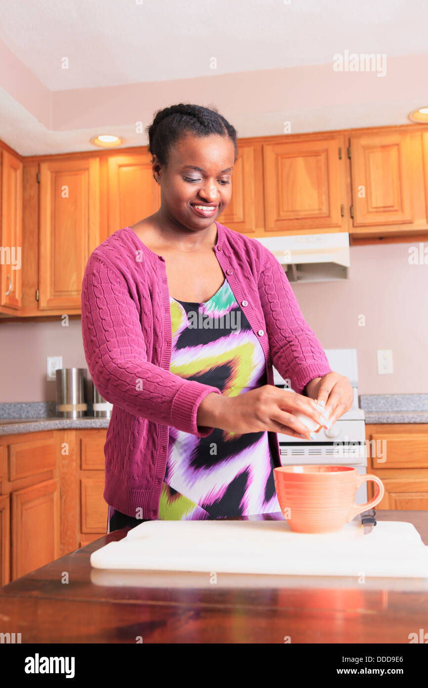 Woman with learning disability cooking in the kitchen Stock Photo