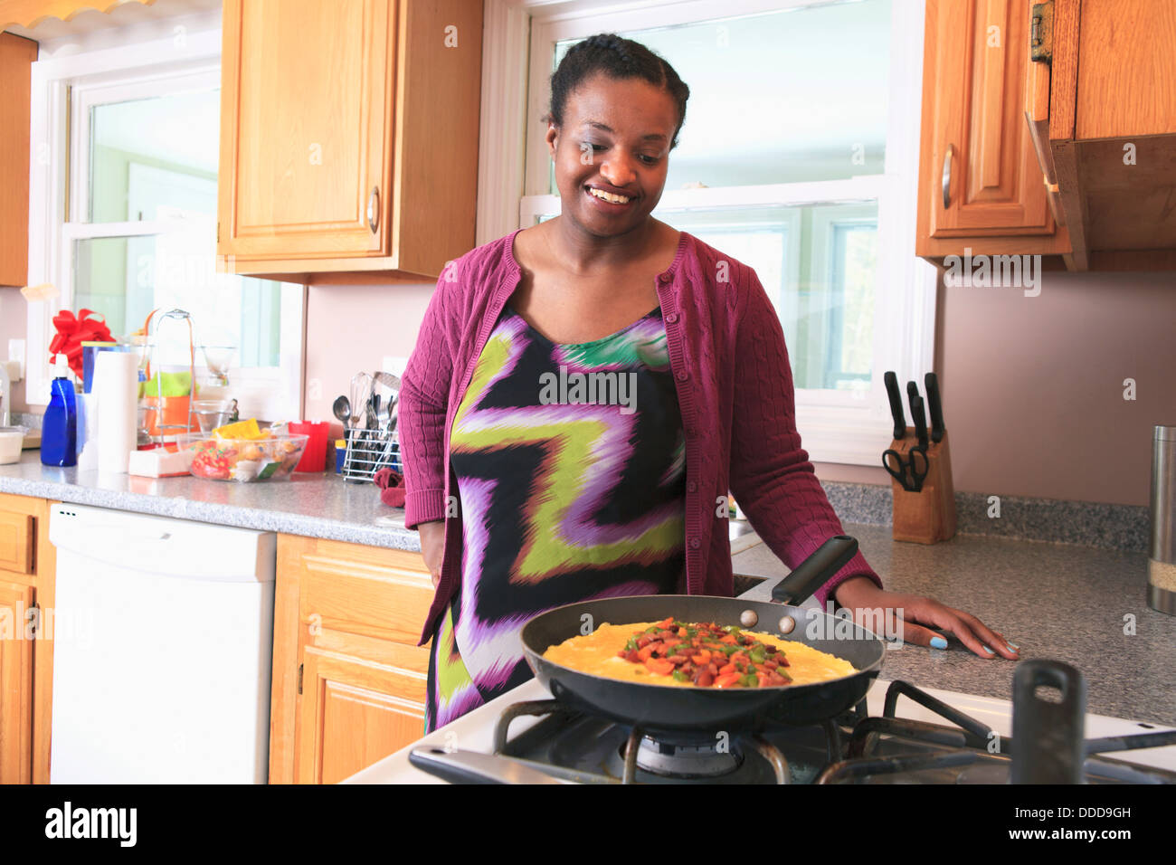 Woman with learning disability cooking in the kitchen Stock Photo