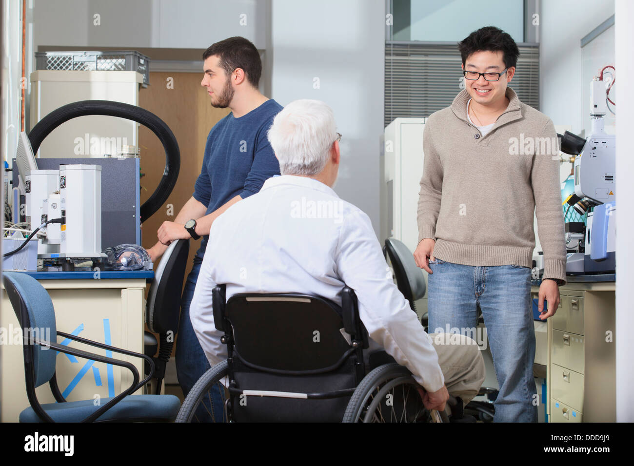 Professor with muscular dystrophy talking to engineering students about