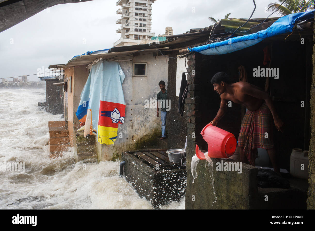 A monsoon storm flooding a small village community by the sea in Bandra, Mumbai, India. Stock Photo