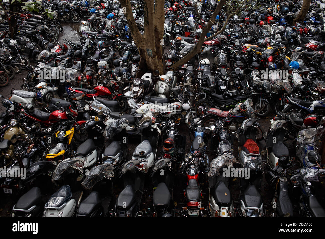 A packed motorcycle motorbike parking lot outside suburban Kandivali train station in Mumbai, India. Stock Photo