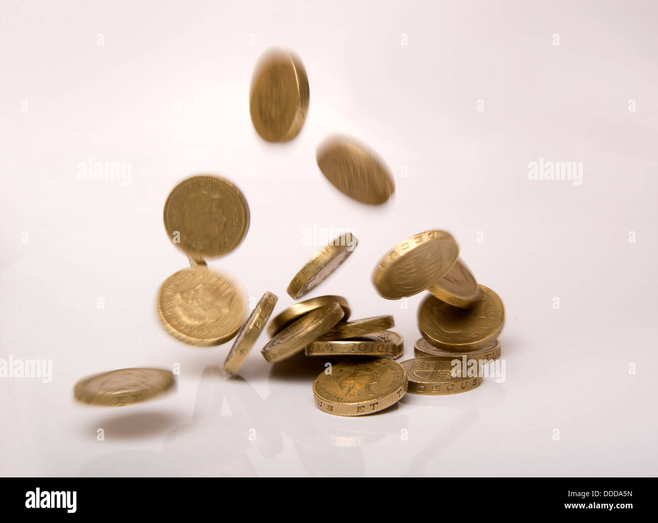 Coins Falling, one Pound, gold, heads tails, mint currency, money, austerity, treasury, £,1, spending, savings, Stock Photo