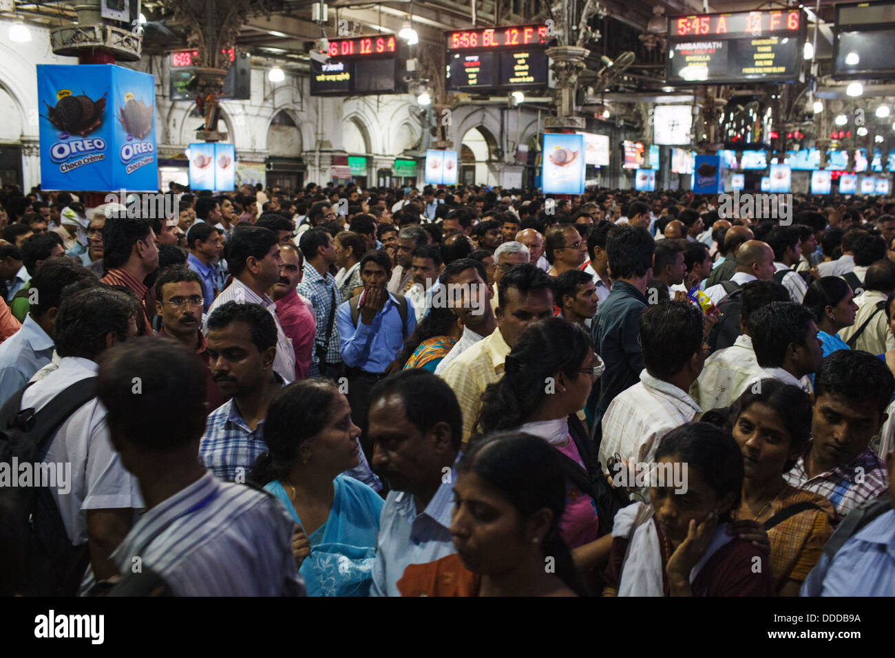 Passengers and trains at crowded Chhatrapati Shivaji Terminus (Victoria Terminus) railway station in Mumbai, India. Stock Photo