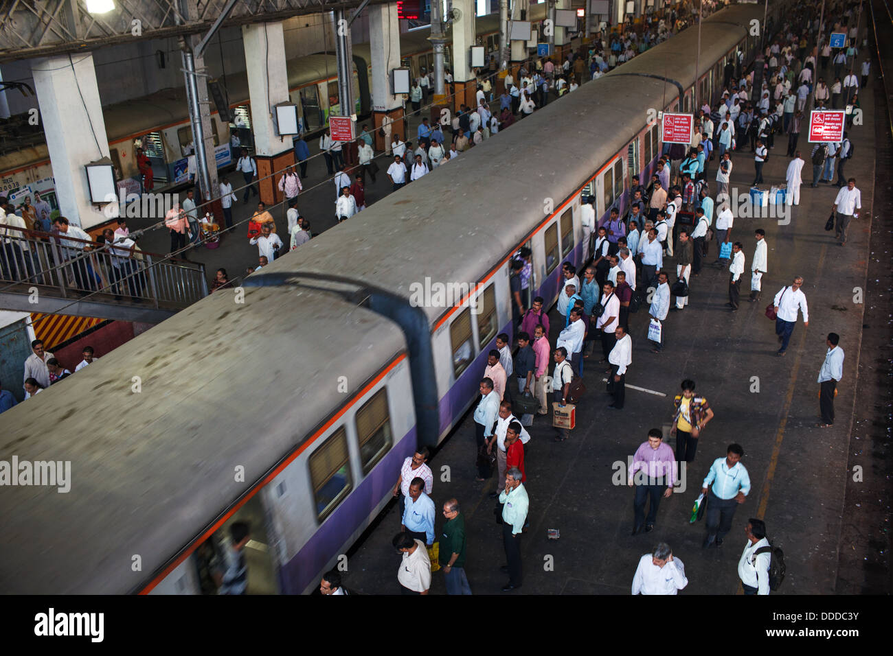Passengers and trains at crowded Chhatrapati Shivaji Terminus (Victoria Terminus) railway station in Mumbai, India. Stock Photo