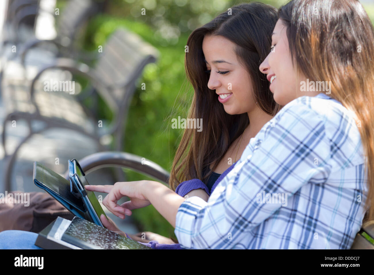 Two Happy Mixed Race Students Using Touch Pad Computer Outside Together on Campus. Stock Photo
