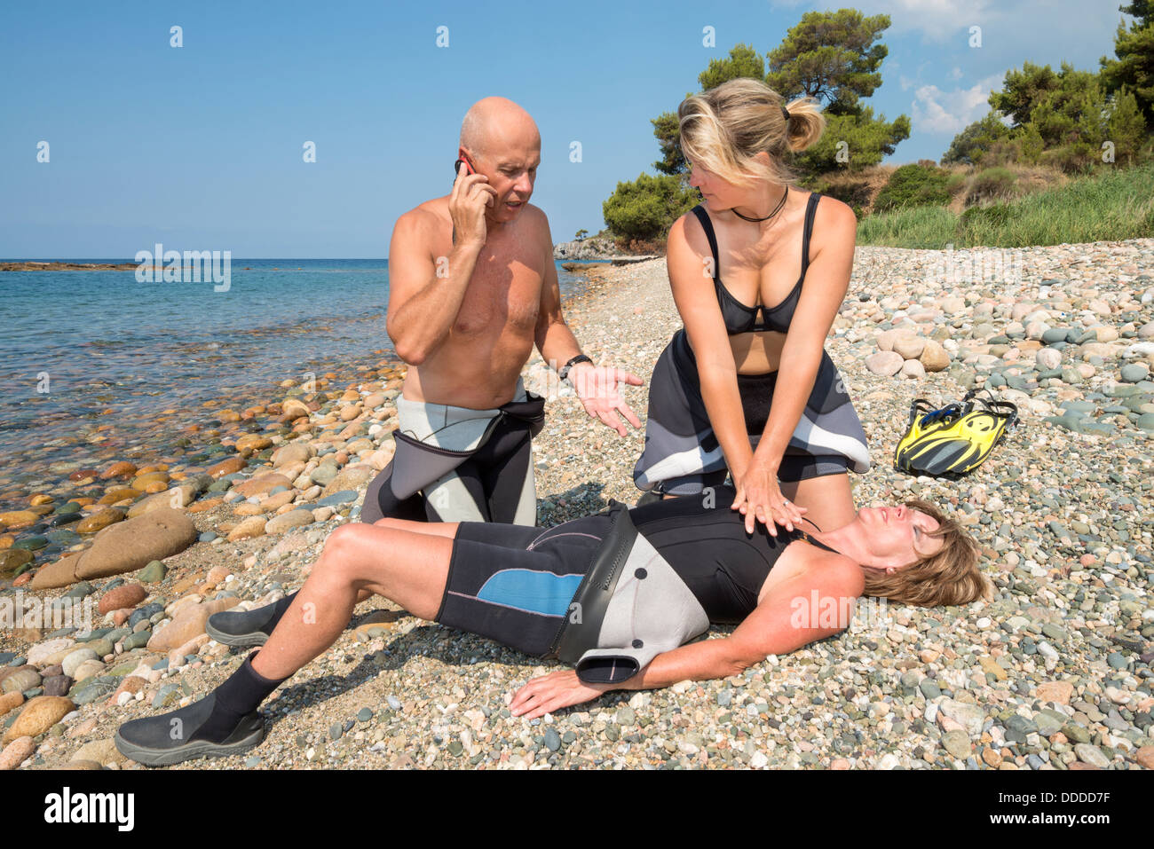 CPR training on a scuba diver on a beach Stock Photo
