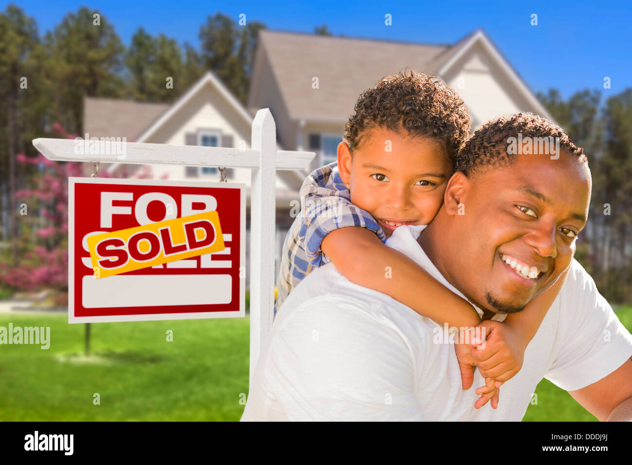 Happy Mixed Race Father and Son In Front of Sold Real Estate Sign and ...