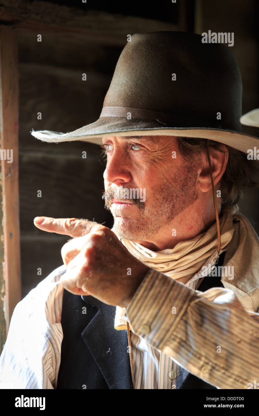 A cowboy points out a window Stock Photo