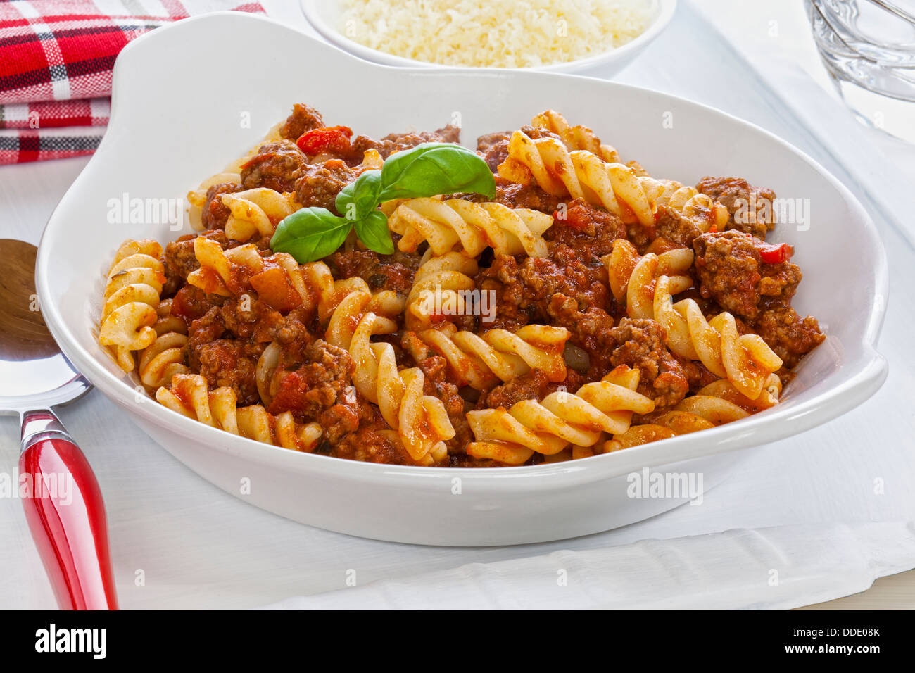 Pasta Bolognese - fusili pasta with bolognese sauce and parmesan cheese on the side. Stock Photo