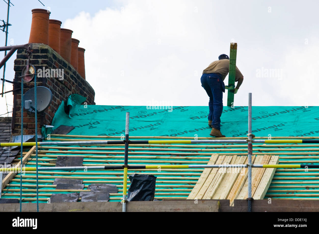 Builder working on roof of period house in the city of York North Yorkshire England UK Stock Photo