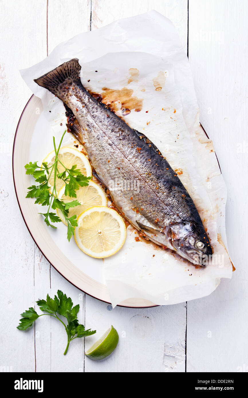 Baked trout with lemon and herbs on wooden background Stock Photo Alamy