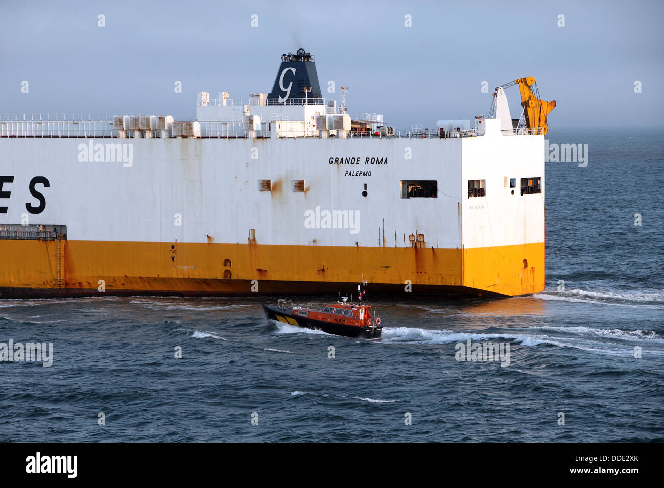 Pilote boat at work with a cargo or container boat, France. Stock Photo