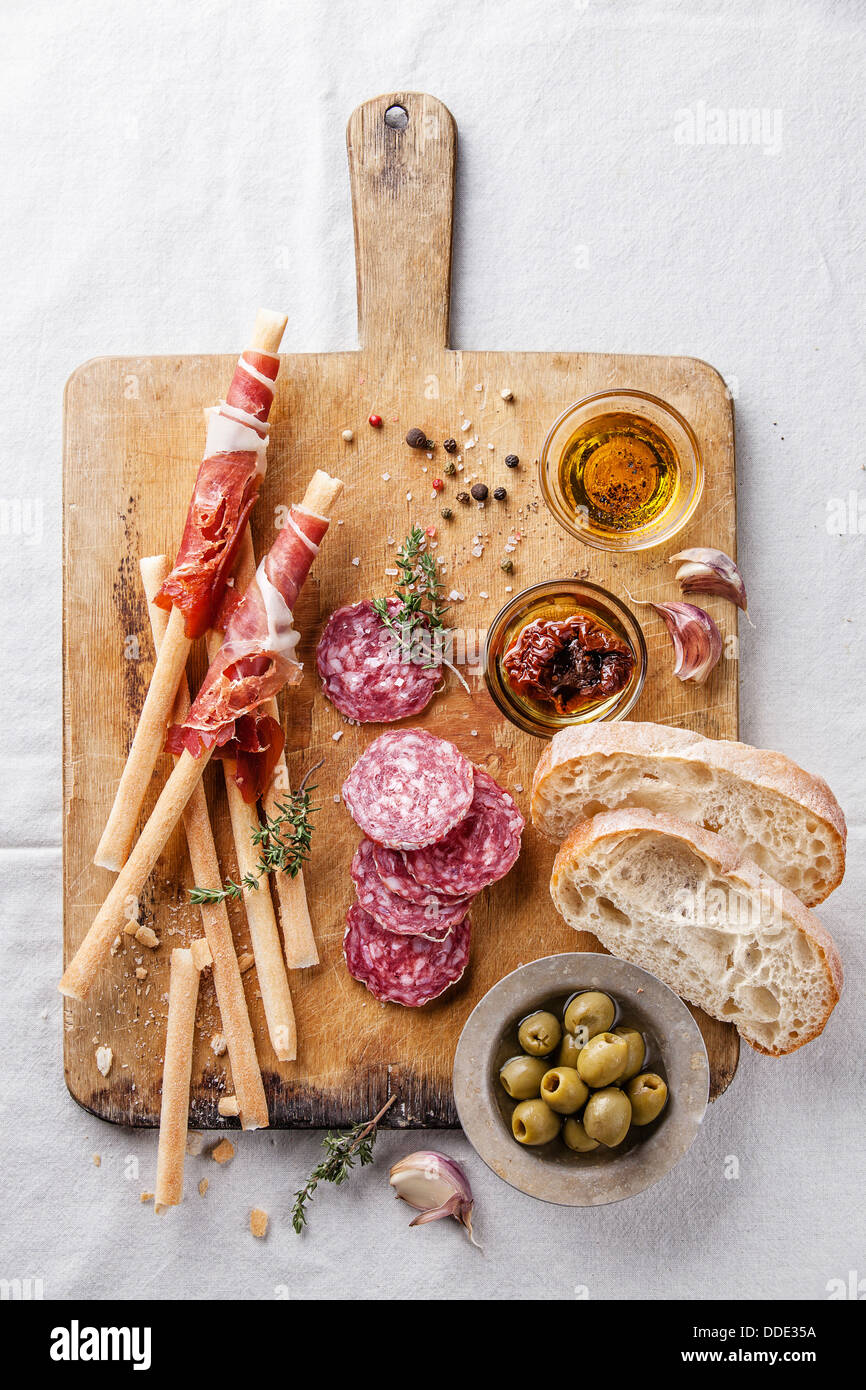 Bread sticks with ham and salami on wooden background Stock Photo
