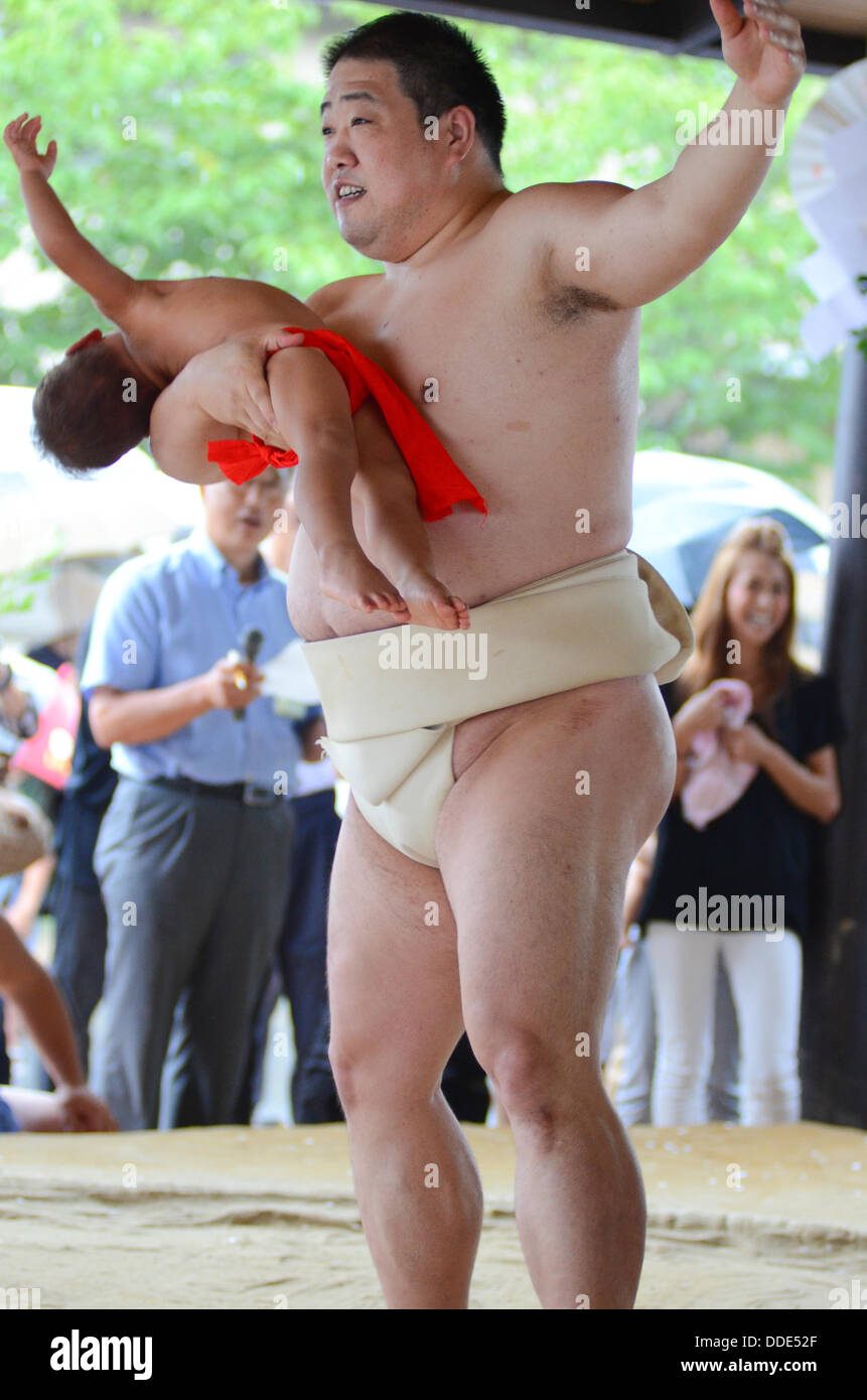 Wrestlers and babies take part in a sumo event at Matsuo Taisha Shrine in Kyoto, Japan. Stock Photo