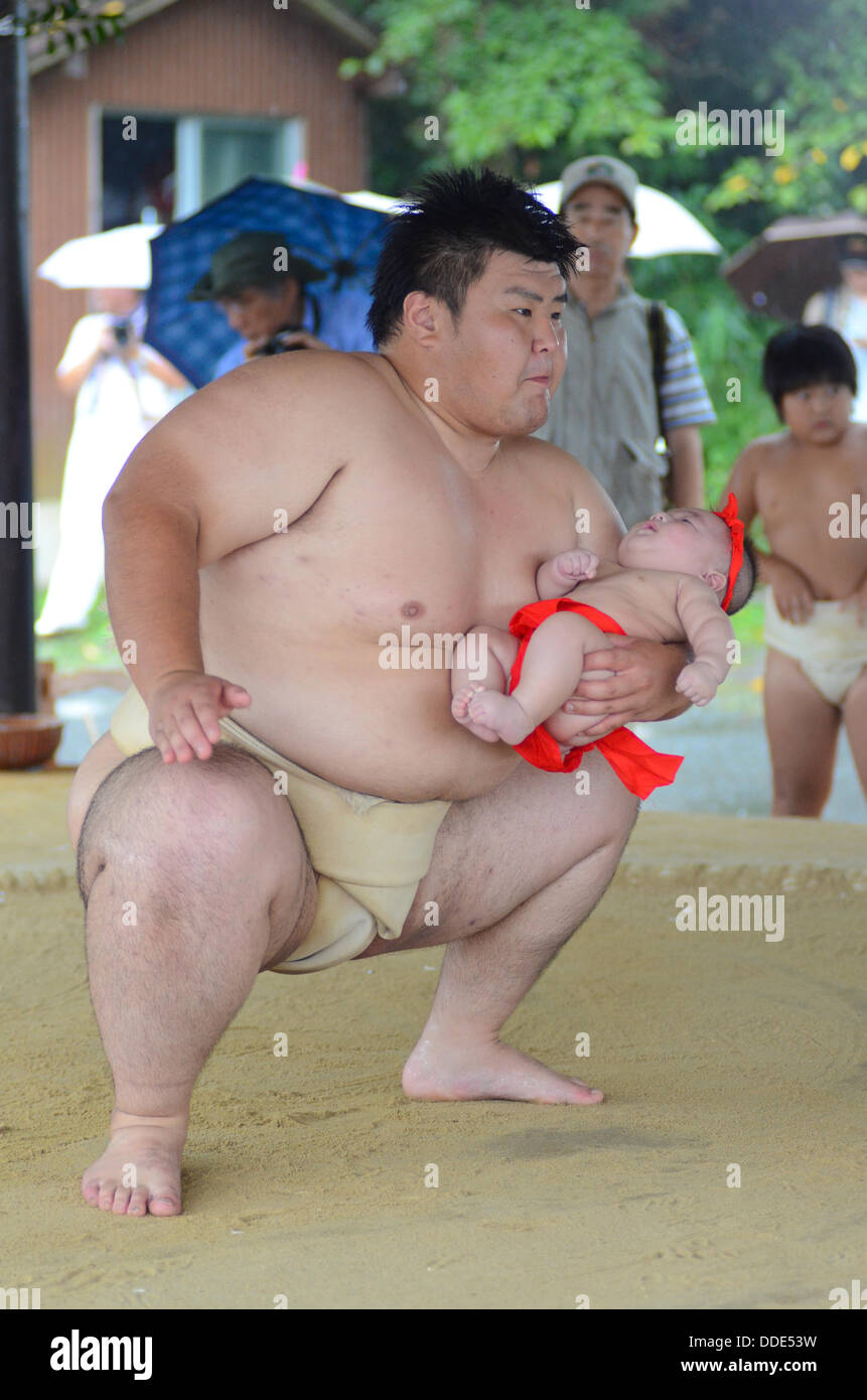 Wrestlers and babies take part in a sumo event at Matsuo Taisha Shrine in Kyoto, Japan. Stock Photo