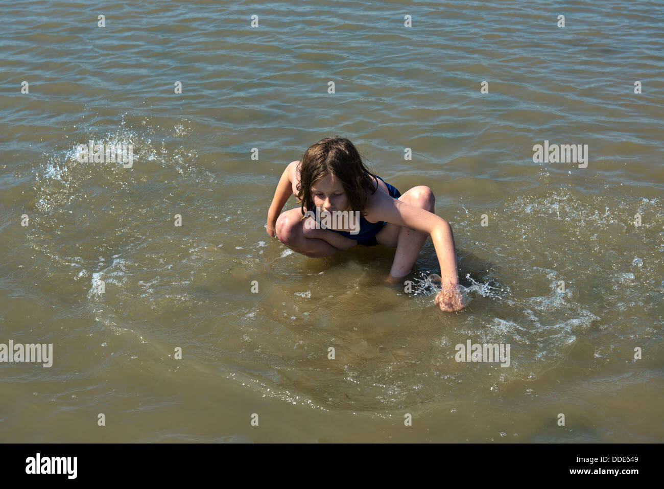 Model released image of a young girl playing in the waves at Southend on Sea, Essex. Stock Photo