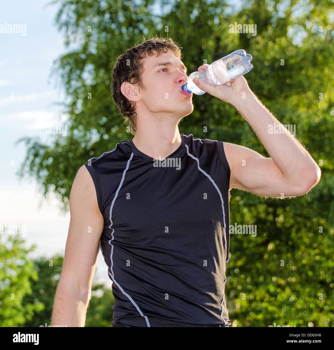 Sportsman drinking water from bottle after workout Stock Photo - Alamy