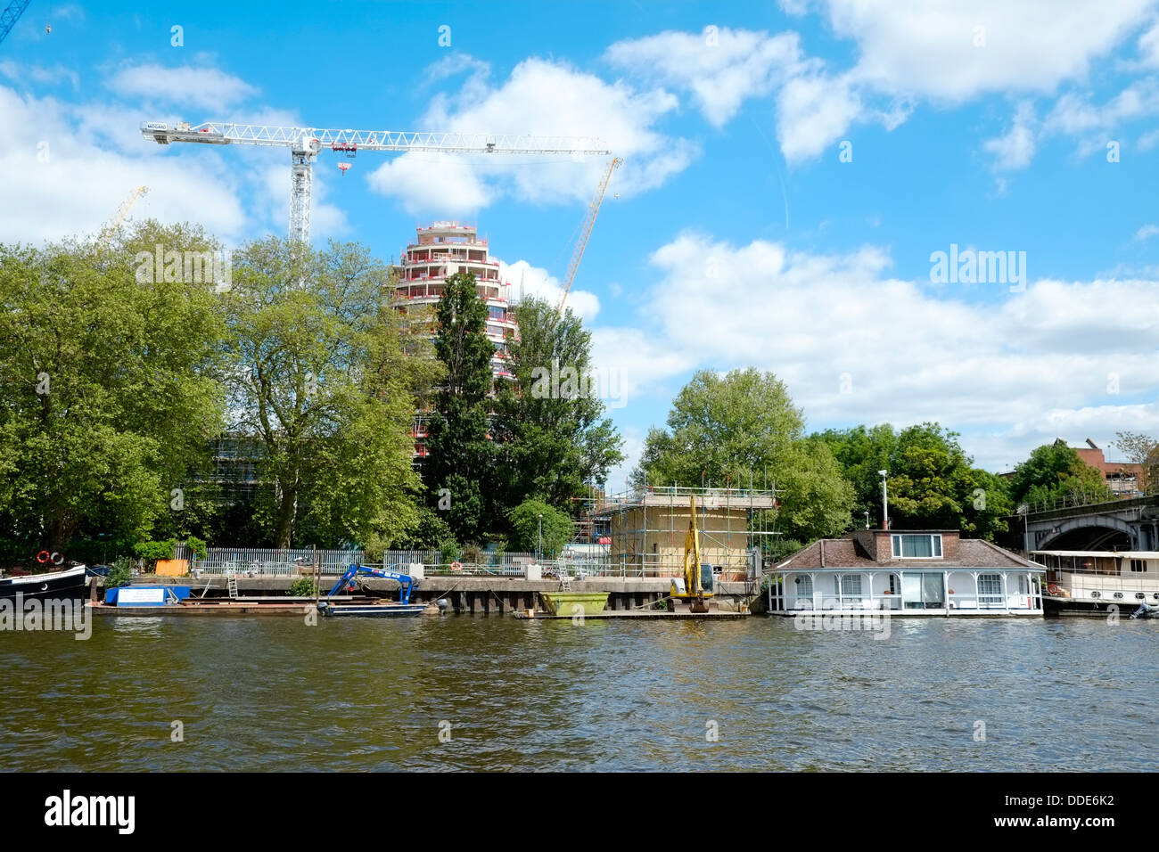 A new high quality housing and hotel development, Kingston Riverside, towers above houseboats at Kingston Upon Thames. Stock Photo