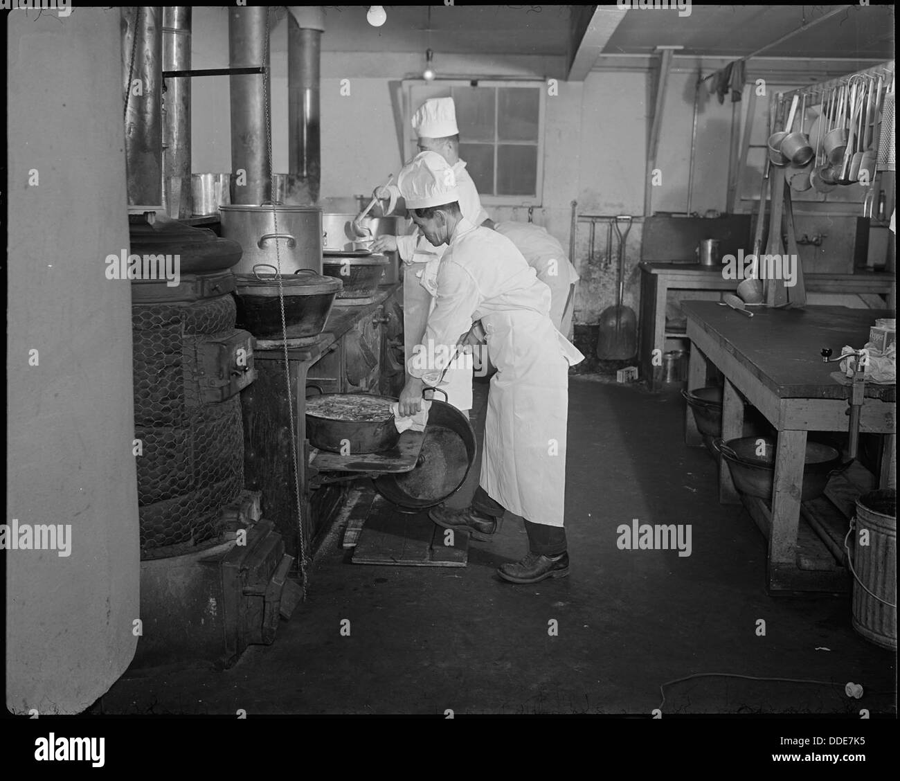 At the Minidoka Relocation Center, a crew of chefs prepares lunch under ...