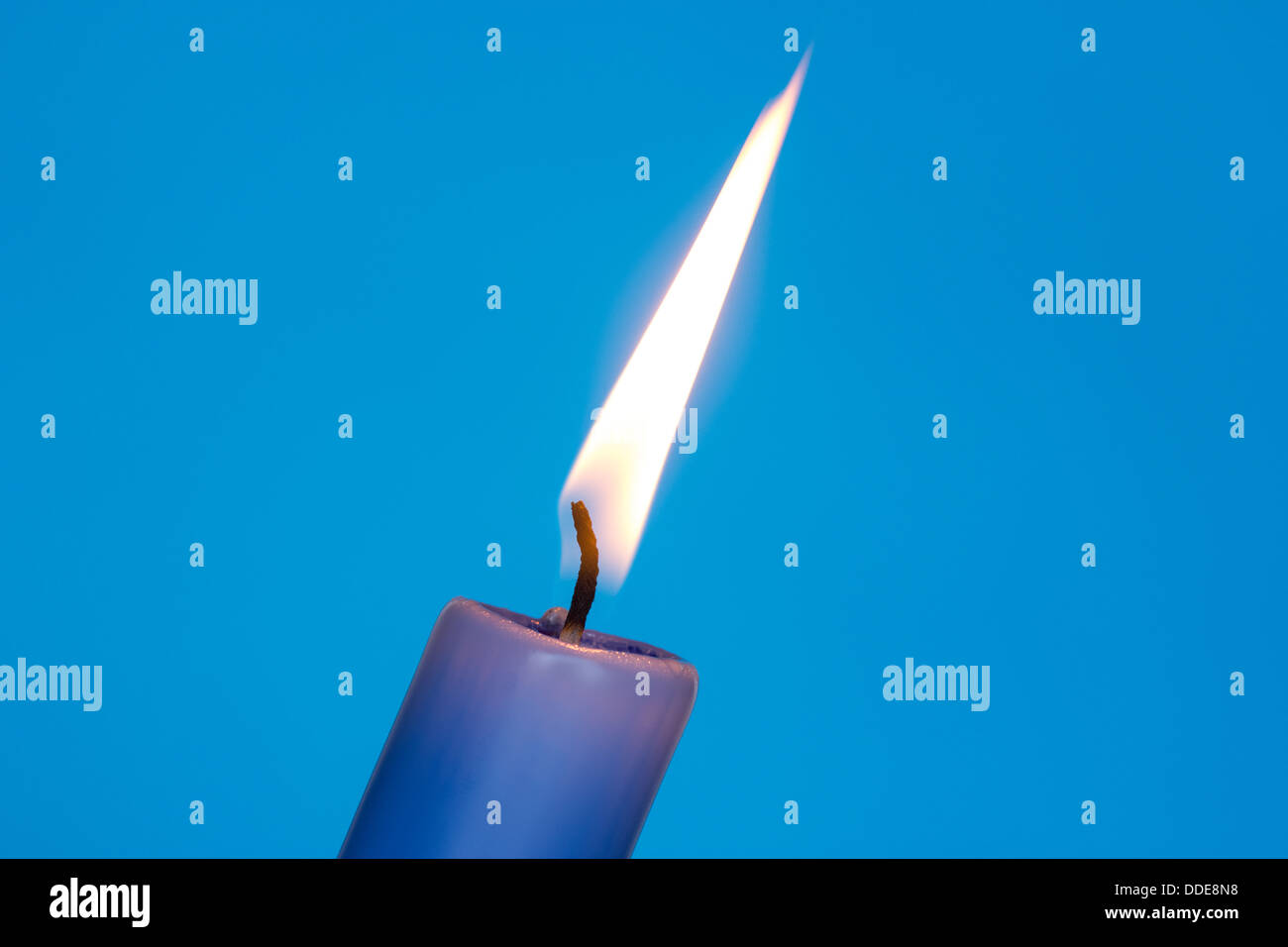 Flame of blue candle on the blue background Stock Photo - Alamy