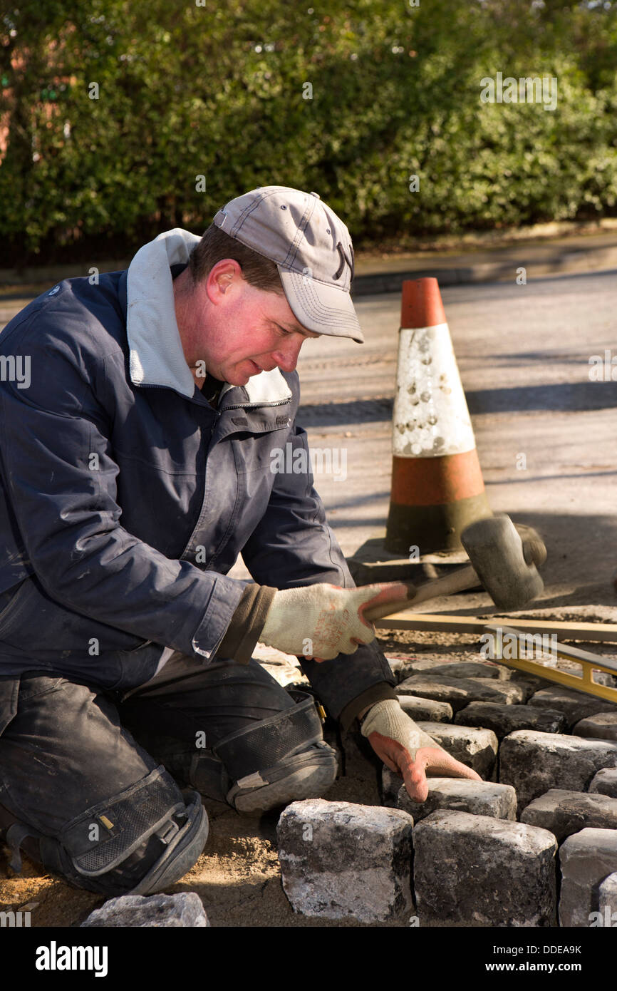 self building house, hard landscaping, workman laying reclaimed granite