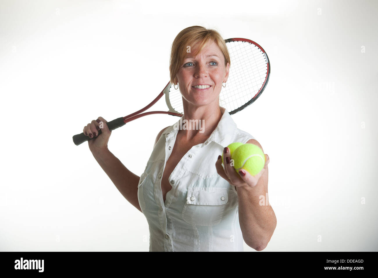Using A Racquet Portrait of a female tennis player holding a racquet and two balls with ...