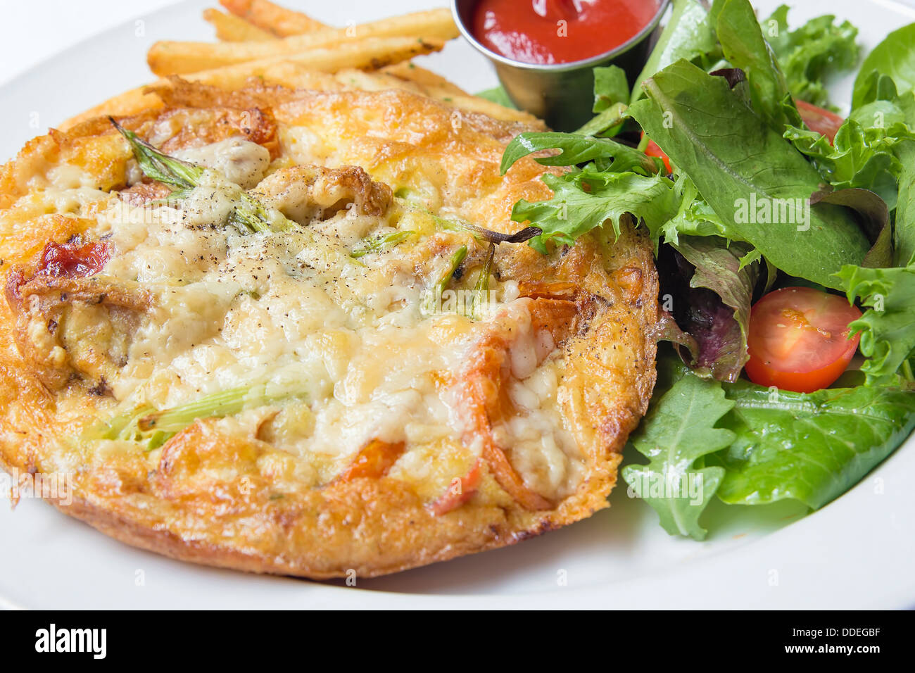Frittata Egg Dish with Cheese Sun Dried Tomato Sauteed Onions Vegetable with Organic Green Salad Closeup Stock Photo