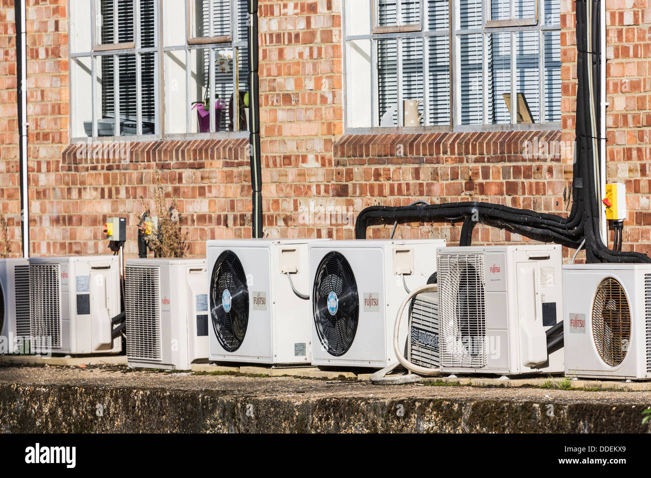 Row of airconditioning units outside an old brickbuilt warehouse