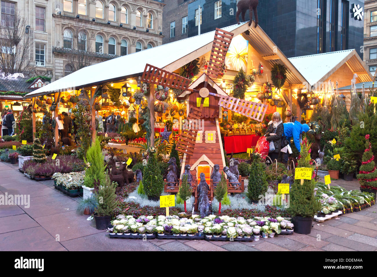 Customers browsing a stall selling potted conifers, wreaths and decorations at the Christmas Market, St Enoch Square, Glasgow Stock Photo