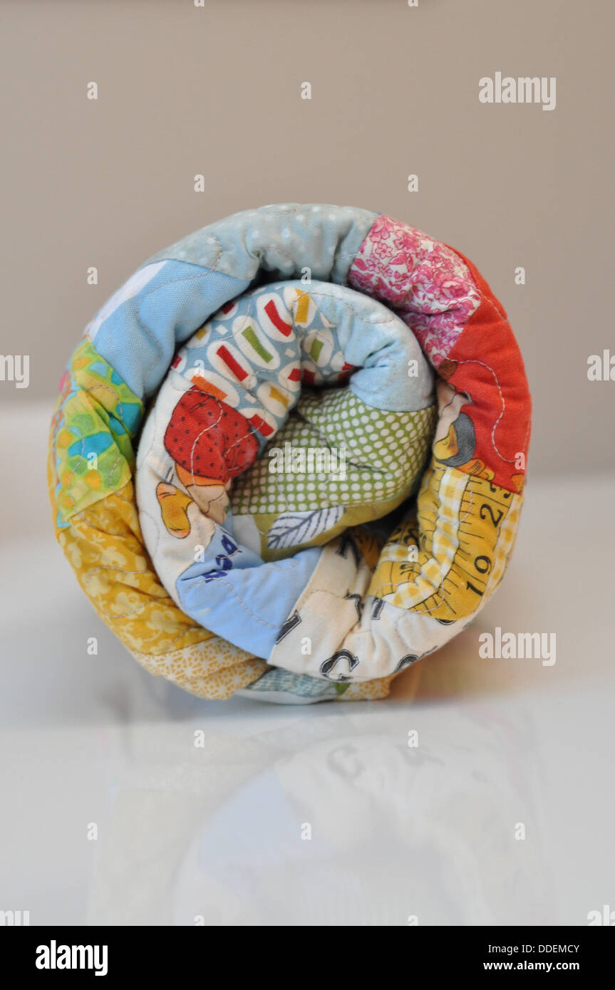 Colourful rolled fabric patchwork quilt Stock Photo