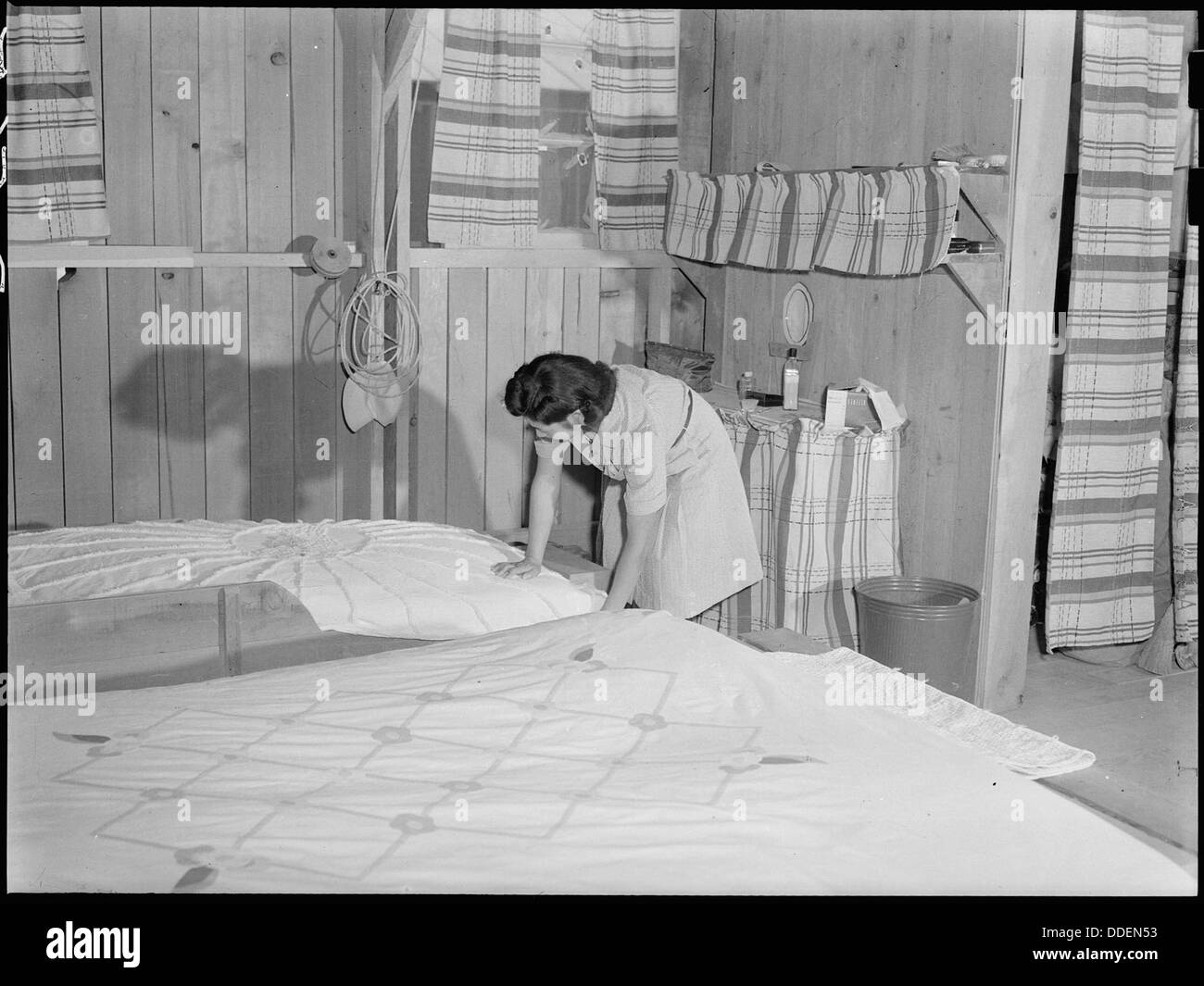 Poston, Ariozna. Mrs. Iwasaki tidies up her home at this War Relocation Authority center. Her fami . . . 538530 Stock Photo