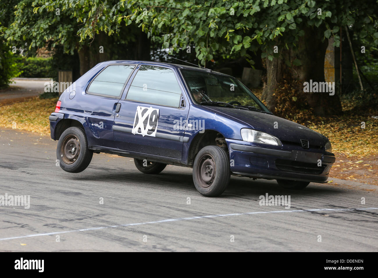 Old peugeot 106 rally car taking a curve on 3 wheels. Stock Photo
