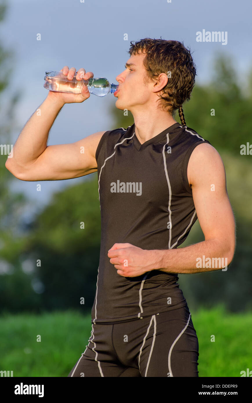 Sportsman drinking water from bottle after workout Stock Photo - Alamy