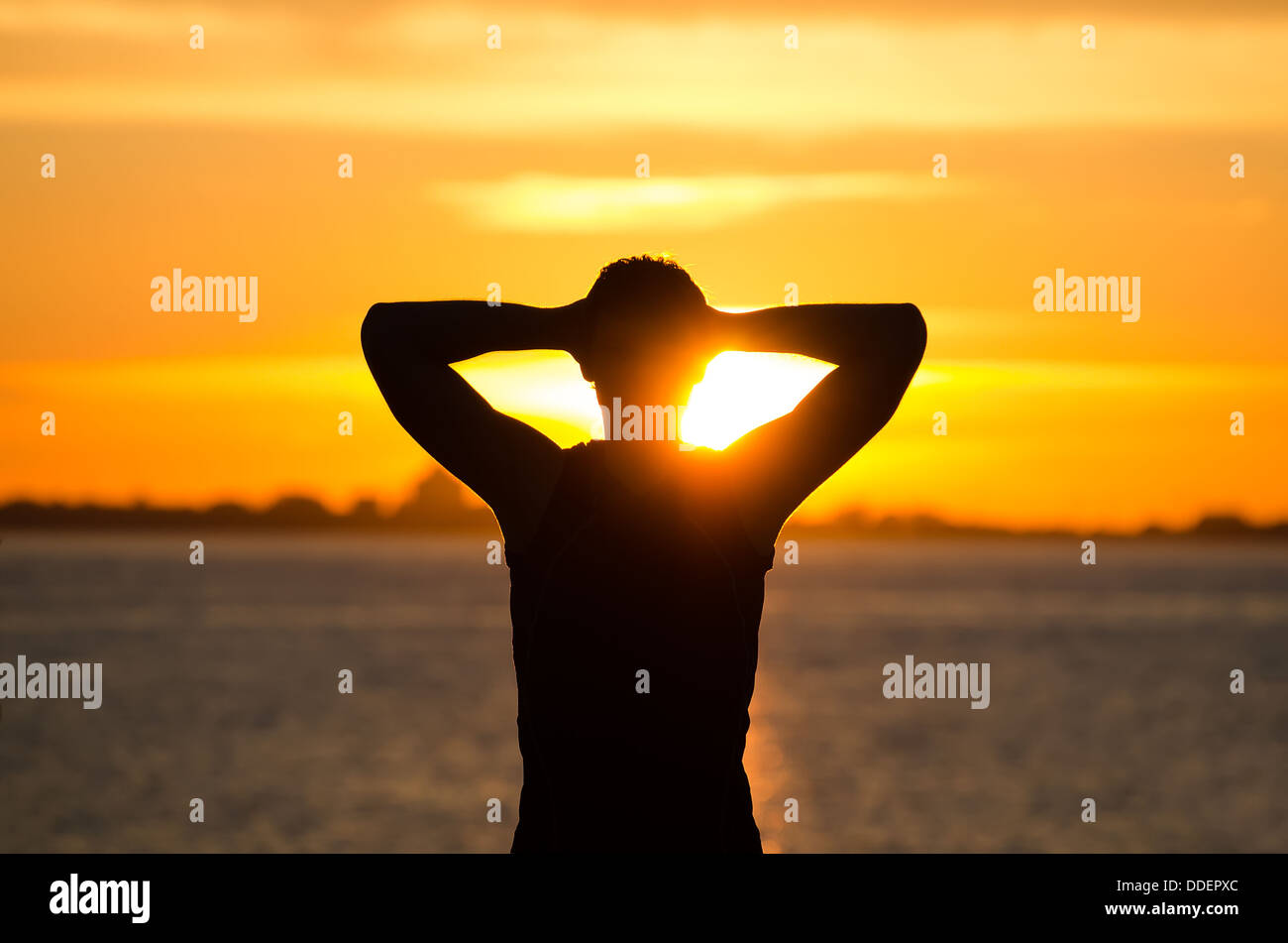 Man on the beach at sunrise Stock Photo