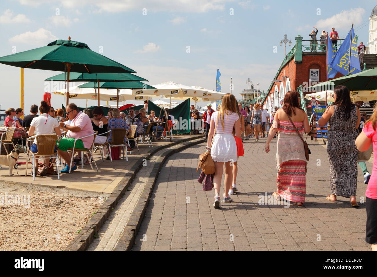 Cafes and people on Brighton seafront beach and promenade East Sussex England UK Stock Photo