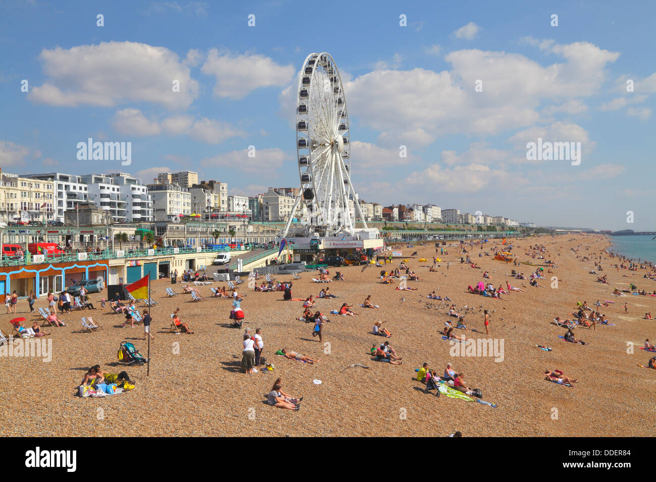 Holidaymakers sunbathing on Brighton beach on a sunny summers day, East ...