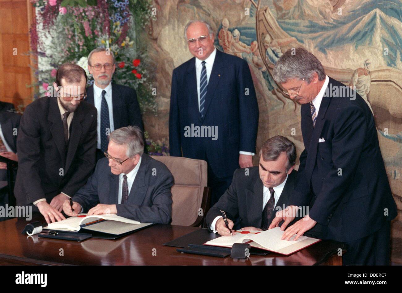 Minister president of the GDR Lothar de Maiziere (back, left) and German chancellor Helmut Kohl (back, m) during the signing of a contract between minister of finance of the GDR Walter Romberg (sitting, left) and Federal Minister of Finance Theo Waigel (sitting, right) on the 18th of May in 1990. The treaty became effective on the 1st of July in 1990. Stock Photo