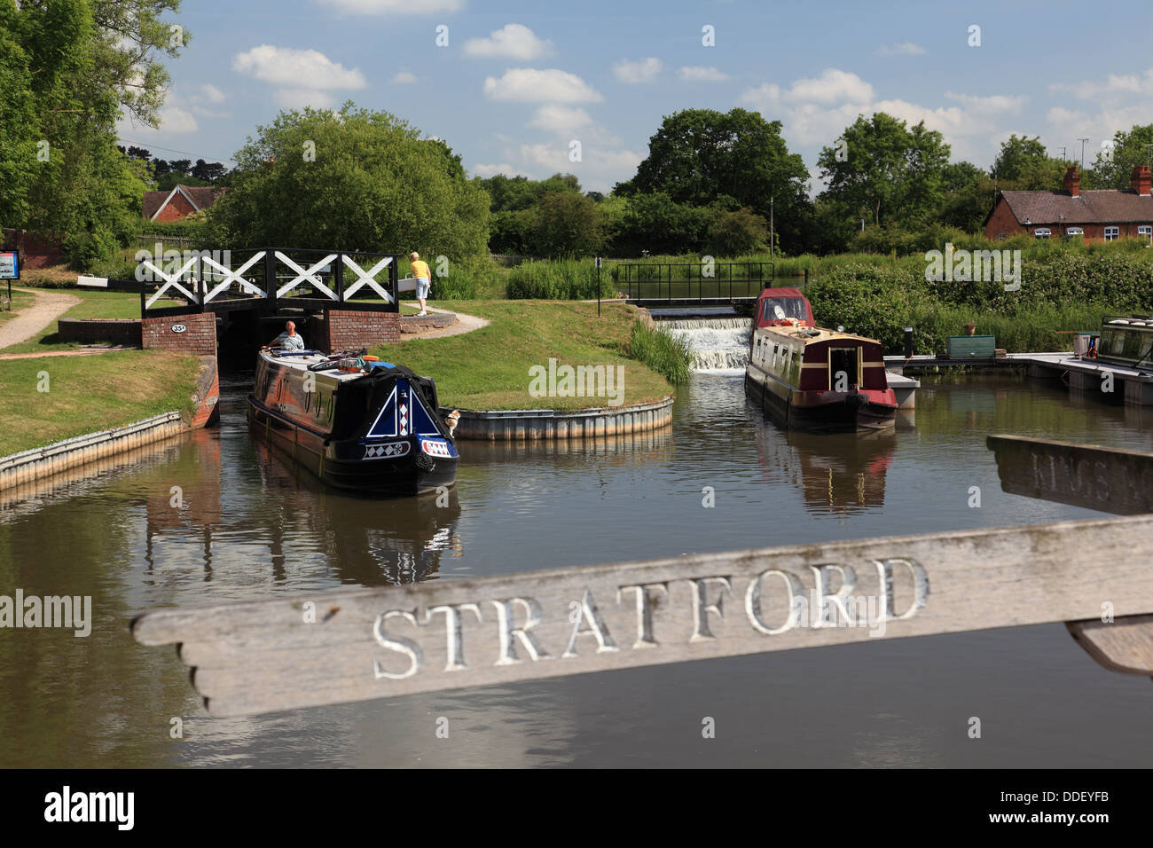 A narrowboat arriving at Kingswood Junction emerging from Lock 19 of the Lapworth flight of locks on the Stratford on Avon Canal Stock Photo