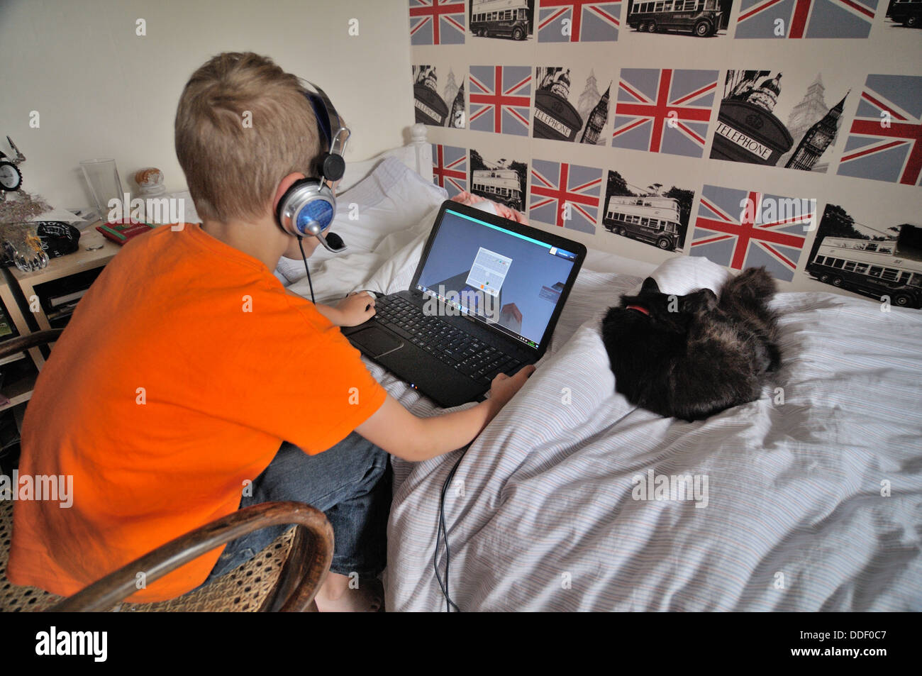 Young boy playing computer games on line in bedroom Stock Photo