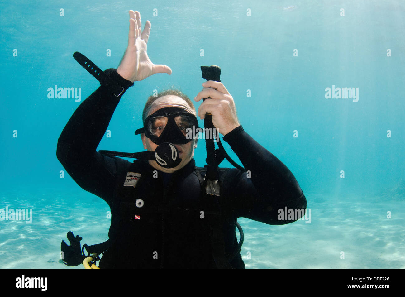 Deflate Buoyancy compensator Underwater Hand signs scuba diver demonstrates the sign language for divers. Stock Photo
